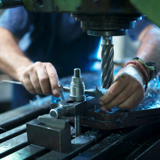 Worker Operating Industrial Machine In Metal Workshop. Worker Operating Industrial Machine In Metal Workshop.